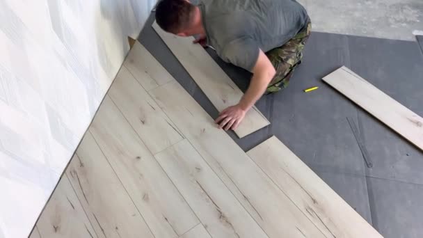기판에 파케트 보드를 놓습니다 건축가의 작품입니다 남자가 바닥을 수리합니다 폴리우레탄 — 비디오