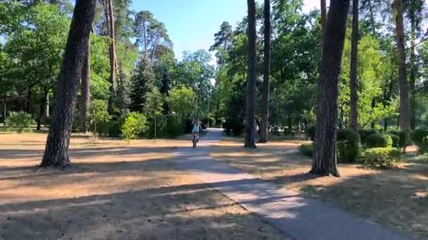 Płynna Jazda Rowerze Widok Tyłu Wzdłuż Ścieżek Parku Dziewczyna Pedałuje — Wideo stockowe