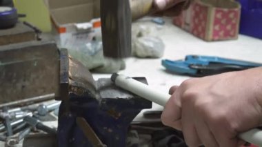 Garajda çalış. Bacaları temizlemek için çubuk üretimi. Endüstriyel amaçlı uzatma kablosu. Çekiçle vurulan bir örs. Yüksek kalite 4k görüntü
