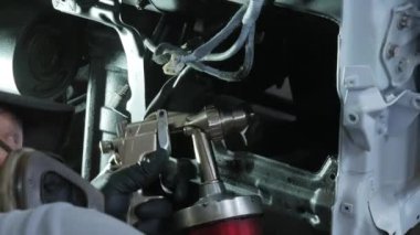 Kaporta ve boyama uzmanı işini yapıyor. Korozyon önleyici materyallerle kamyonun tedavisi. Bir araba atölyesinde çalışan bir ressamın yakın çekimi. Yüksek kalite 4k görüntü