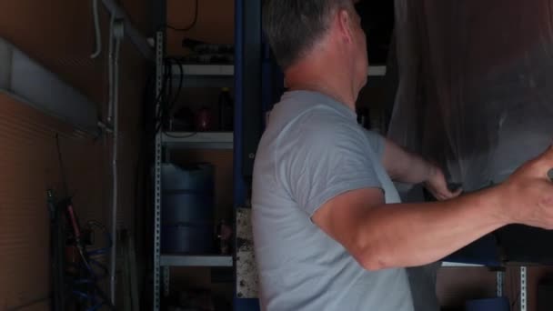 汽车服务中心的一名员工正在准备一辆汽车来进行油漆工作 一个穿着灰色T恤的年轻主人的汽车加工 高质量的4K镜头 — 图库视频影像