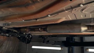 Arabanın altı, aşağıdaki yeni arabanın manzarası, asansördeki araba. Servis merkezindeki arabanın durumunu kontrol eden görevli, arabanın durumunu da kontrol ediyor. Yüksek kalite 4k