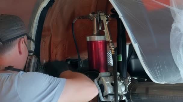 客车防腐蚀处理工具的研制 汽车的防腐蚀处理 工人将罐体与用蜡覆盖金属的准备材料连接到气枪上 — 图库视频影像