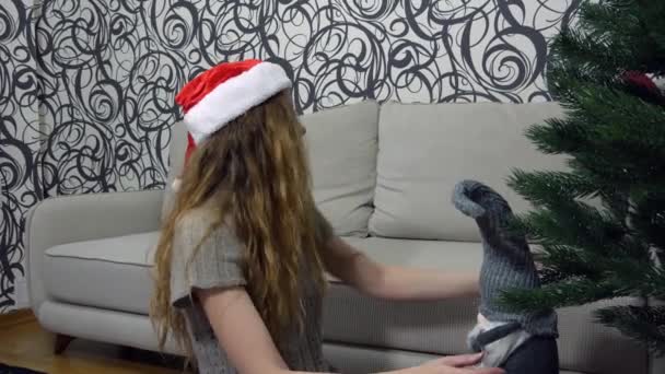 Dívka Vánočním Klobouku Sedí Pod Vánočním Stromečkem Pohovky Pokoji Rozkládá — Stock video