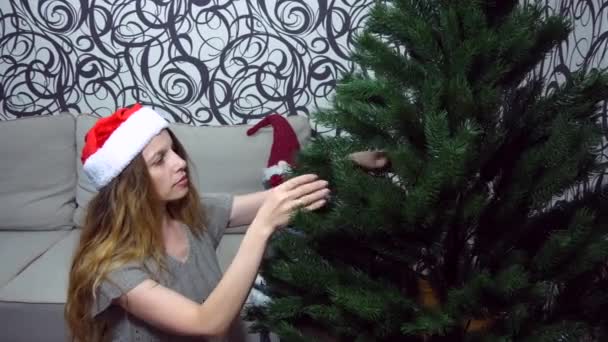 여자는 그녀가 크리스마스 트리의 가지를보고 소녀는 스튜디오에서 크리스마스 트리의 가지의 — 비디오