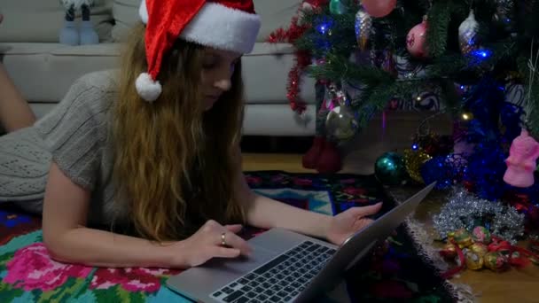 Dziewczyna Noworocznym Kapeluszu Laptopie Koło Magicznej Choinki Dziewczyna Spoczywa Kolorowym — Wideo stockowe