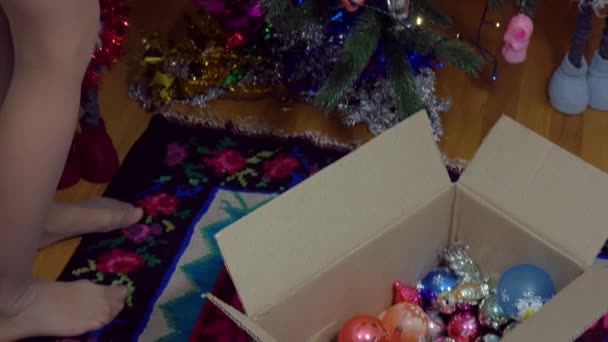 소녀가 크리스마스 트리를 장식하는 사용하는 새로운 장난감의 드레스를 그녀의 머리에 — 비디오