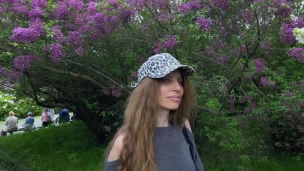 Młoda Kobieta Stoi Troskliwie Tle Kwietniowego Bzu Ogrodzie Botanicznym Spacer — Wideo stockowe