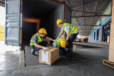İşçi, 12 metre çelik konteynırdan alınmış karton kutu taşıyor. Kazadan yere düşmüş.