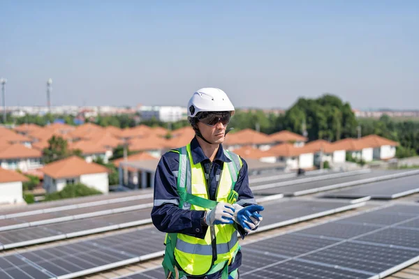 天台的工程师站在太阳能电池板旁边 戴着安全装置 手戴手套 随时准备工作 — 图库照片
