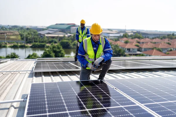 屋顶工程师跪在太阳能电池板旁边 手持工具安装光伏 — 图库照片
