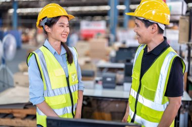 Geniş depo deposunda çalışan personel stajyer öğrenci kutusunu kontrol ediyor ve kasiyeri tarıyor.