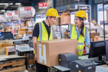 2 personel büyük depo deposunda çalışıyor. Ambalaj kutusunu işaretle ve kasiyeri tara.