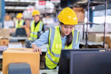 Büyük depo deposunda çalışan işçiler kasiyerlerin kasasında mutlu bir şekilde gülümsüyorlar.