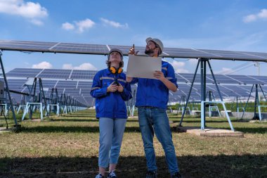 Güneş çiftliğindeki bakım mühendisleri elektrik santralinin genişletilmesi konusunu tartıştılar.