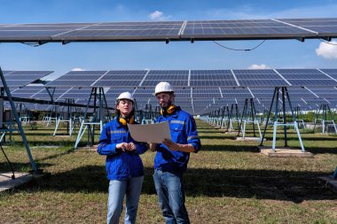 Güneş çiftliğindeki bakım mühendisleri elektrik santralinin genişletilmesi konusunu tartıştılar.