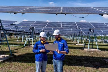 Güneş çiftliğindeki bakım mühendisleri elektrik santralinin genişletilmesi konusunu tartıştılar.
