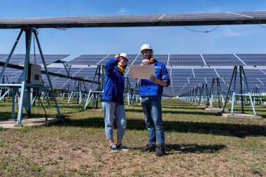 Güneş çiftliğindeki bakım mühendisleri elektrik santralinin genişletilmesi konusunu tartıştılar.