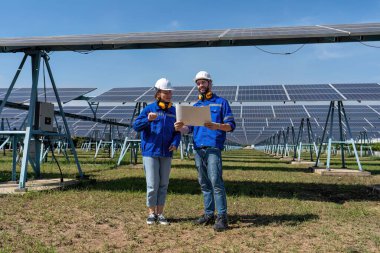 Güneş çiftliğindeki bakım mühendisleri elektrik santralinin genişletilmesi konusunu tartıştılar.
