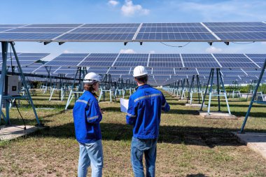 Güneş çiftliğindeki bakım mühendisleri elektrik santralinin genişletilmesi konusunu tartıştılar.