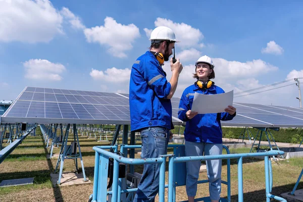 太陽光発電所のメンテナンスエンジニアは シザーリフトの上に立つ 太陽光パネルとラジオの報告書の検査 — ストック写真