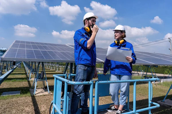 Güneş çiftliğindeki bakım mühendisleri makas kaldırma, güneş panellerini teftiş ve radyo raporları üzerinde duruyorlar. 
