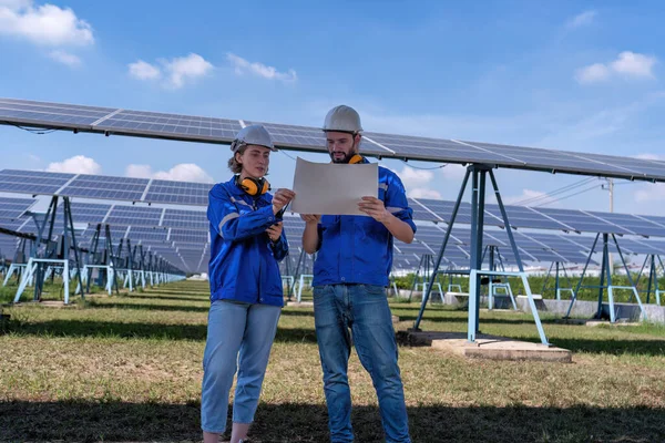Güneş çiftliğindeki bakım mühendisleri elektrik santralinin genişletilmesi konusunu tartıştılar.