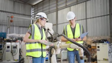 Robot eğitim eğitmeninde kız mühendise dizüstü bilgisayardan robot kolu görünüş kılavuzunu programlamayı öğret