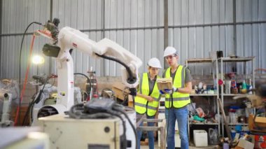 Robot eğitim merkezinde kız mühendise robot kolu nasıl çalıştırıp programlayacağını öğretiyor.