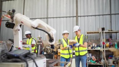 Robot eğitim merkezinde kız mühendise robot kolu nasıl çalıştırıp programlayacağını öğretiyor.