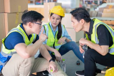 Geniş bir depoda çalışanlar birlikte oturup rahatlayın. Şişe içip dedikodu yapın.