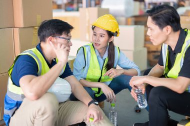 Geniş bir depoda çalışanlar birlikte oturup rahatlayın. Şişe içip dedikodu yapın.