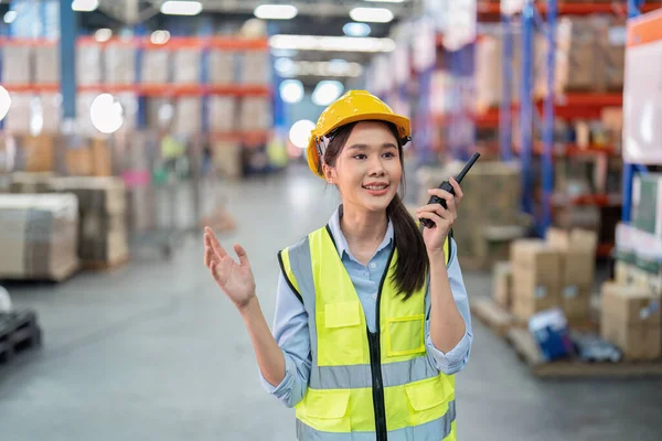 Staff in large storage warehouse use radio walkie talkie explain material storage location to team