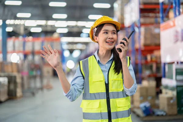 Staff in large storage warehouse use radio walkie talkie explain material storage location to team