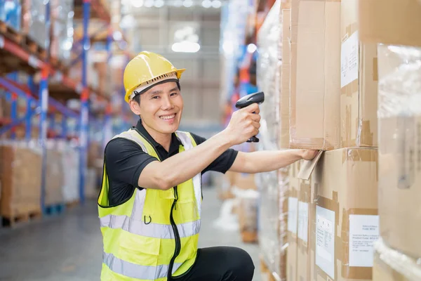 Stock image Staff working in large depot storage warehouse hold wireless barcode scanner scan box at shelf