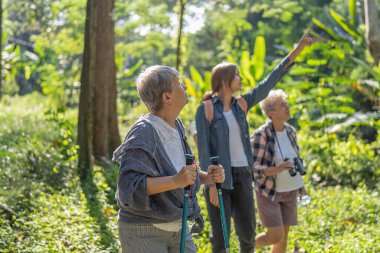 Sırt çantalı turistler, ağaç görünümlü dürbünle gezintiye çıkıyorlar.