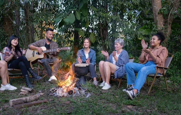 Backpack tourist travel hiking outdoor adventure sit around campfire sing a song with guitar
