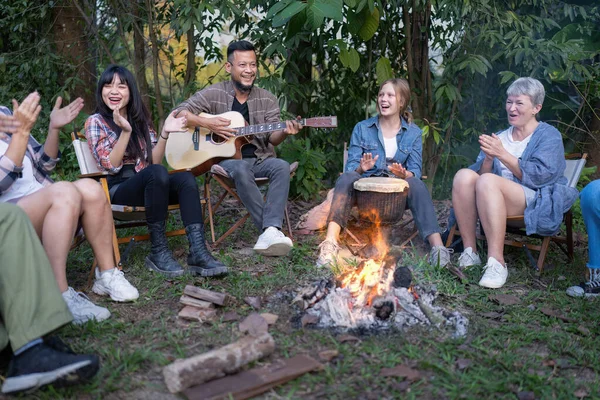 Backpack tourist travel hiking outdoor adventure sit around campfire sing a song with guitar