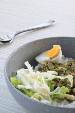 green chili squid rice with salad on wooden table (natural light)