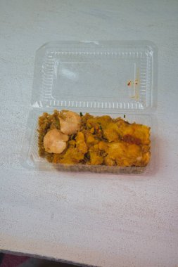 called nasi goreng, packaged fried rice on a white table.