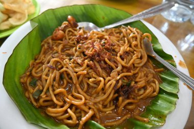 a plate of aceh noodles on a wooden table ( mie aceh ).