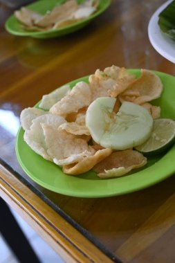 crackers and cucumber on the table as a complement to mie aceh.