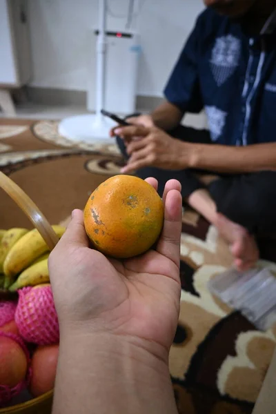an orange in hand at an event.