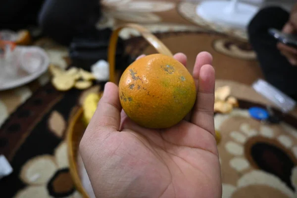 an orange in hand at an event.