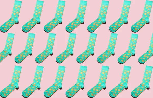 Pastel patterned colourful sock pattern on pink background. Minimalist flat lay concept.