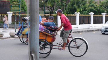 Jalan Malioboro 'daki bisiklet çekçekçekleri Yogyakarta Endonezya' da 27 Aralık 2022 'de bir ulaşım biçimidir..
