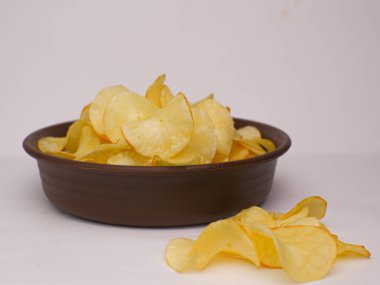 Kahverengi bir kasede beyaz arka planda izole edilmiş Cassava cipsleri.