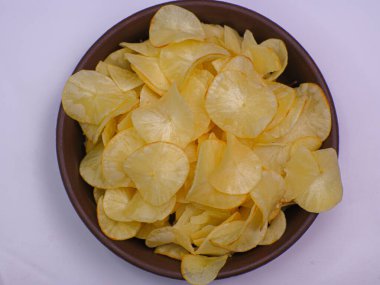 Kahverengi bir kasede beyaz arka planda izole edilmiş Cassava cipsleri.