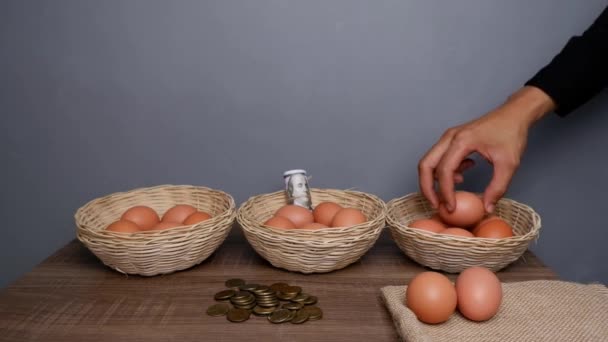 すべての卵を1つのバスケットの概念に入れないでください 籐製の籠の中の卵 — ストック動画