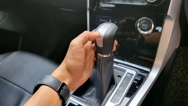 Automatic transmission handle, An Asian man\'s hand is holding the automatic transmission lever